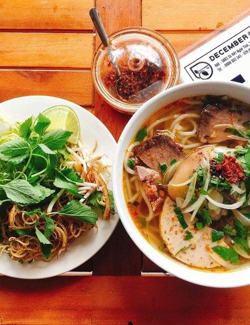 Top view of a delicious noodle soup with fresh herbs, perfect for a hearty meal.